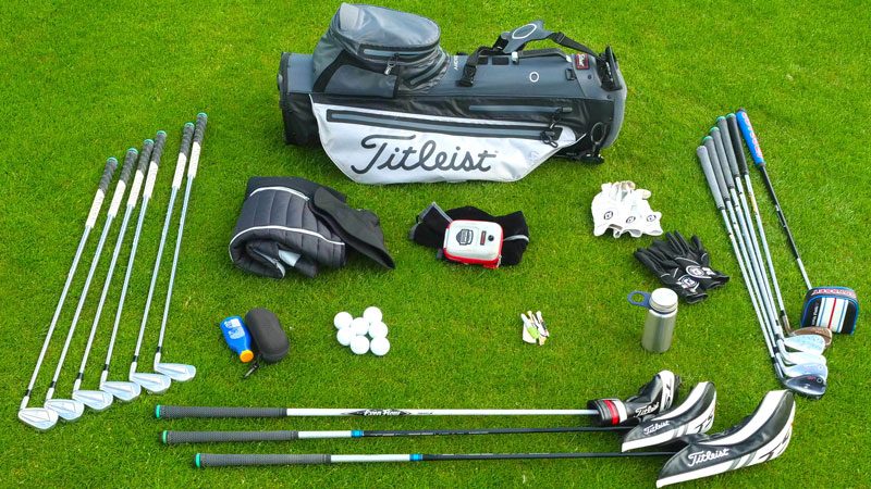 Zestaw podstawowego wyposażenia golfisty obejmujący torbę golfową, kije, piłki, rękawiczki i akcesoria do gry na zielonym polu